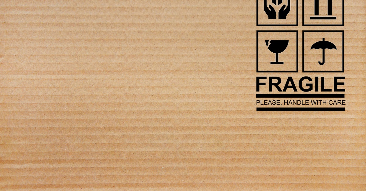 The face of a cardboard box with symbols that signal a fragile product, indicating to handle with care.